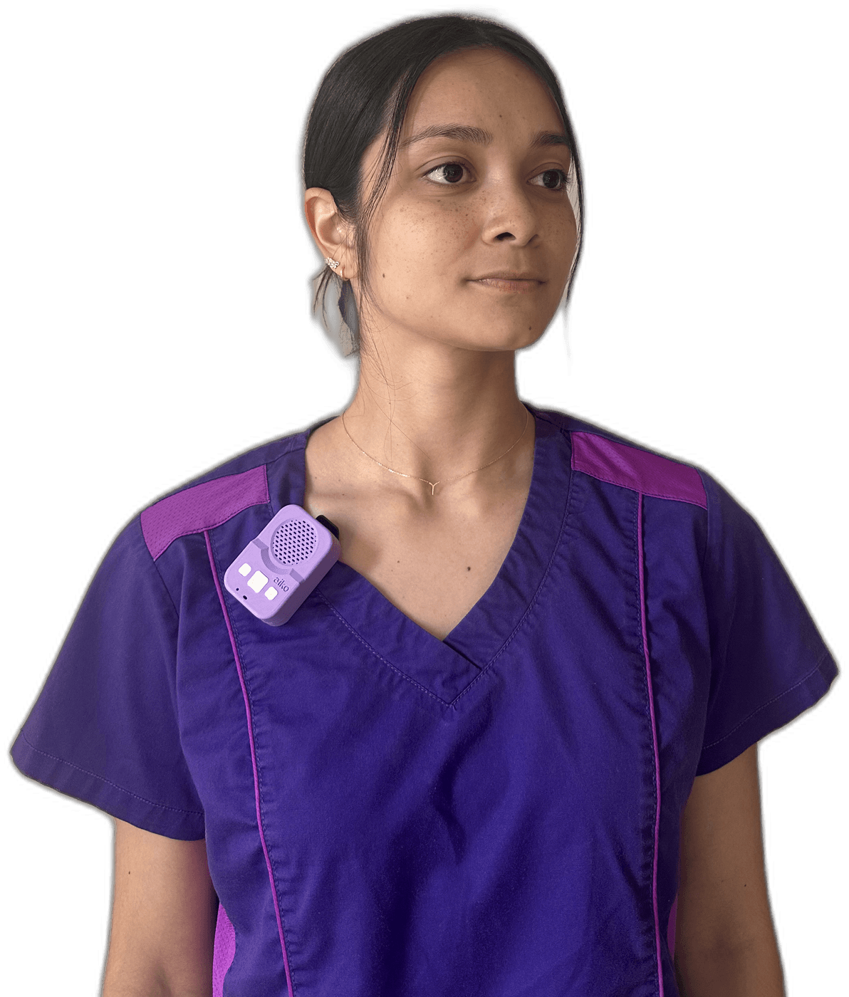 A caregiver in scrubs wearing the small lavender Aiko translation device clipped near her shoulder.